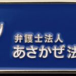 Blue rectangular sign with a white wave logo and the text 'asakaze' beside Japanese characters reading弁護士法人 あさかぜ法律事務所, indicating the Asakaze Law Office.